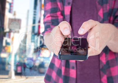 Young men with the phone on his hands in the street