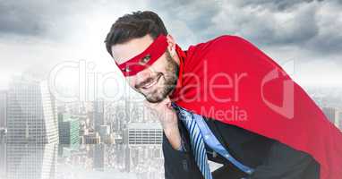 Business man superhero with head on hand against blurry skyline