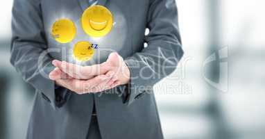 Business man mid section with hands together and emojis with flares in blurry grey office