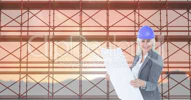 Business woman looking blueprint in front of 3D scaffolding