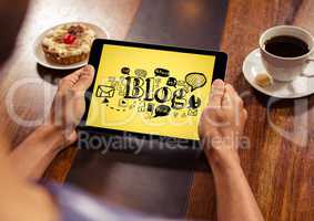 Hands with tablet showing black blog doodles against yellow background