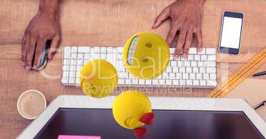 Hands using computer while emojis coming out of it