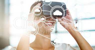 Digitally generated image of cloud computing icons with woman using VR glasses in office