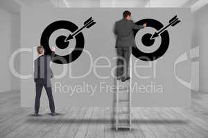 Digital composite image of business people setting targets on wall