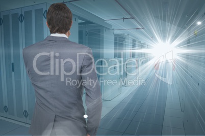 Digital composite image of businessman looking at light at data center