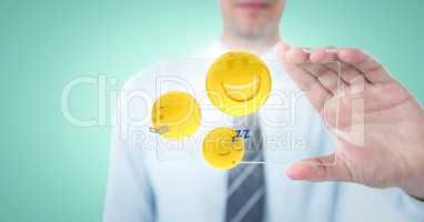 Business man mid section with glass device and emojis with flares against aqua background