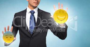 Business man mid section with flares and emojis on hands against blue background