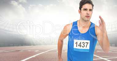 Male runner sprinting on track against flares
