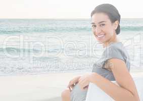 Smiling woman sitting by sea