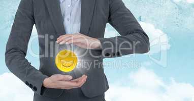 Mid section of business woman with emojis and flares between hands against sky