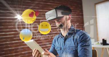 Man with VR glasses and digital tablet using emojis