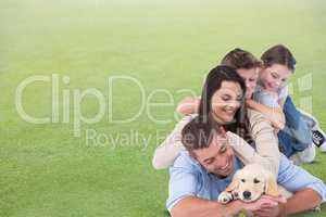 Happy family with dog lying on grass