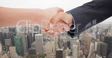 Cropped image of businessmen doing handshake against city