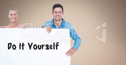 Smiling couple holding bill board with do it yourself text on it