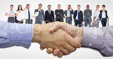 Digital composite image of handshake with business people in background