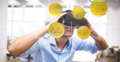 Digital composite image of businessman looking at emojis through VR glasses