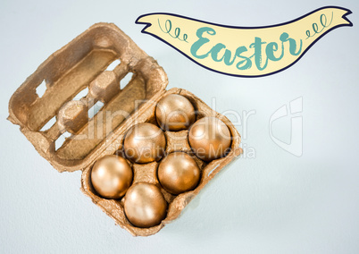 Easter banner and gold eggs in carton against white background