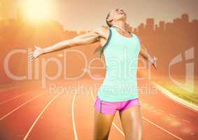 Female runner on track against orange flare and skyline
