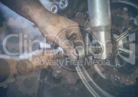 Close up of hands working on wheel with gear graphic overlay