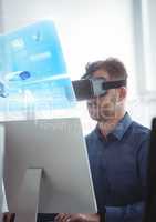 Man on computer wearing VR Virtual Reality Headset with Interface