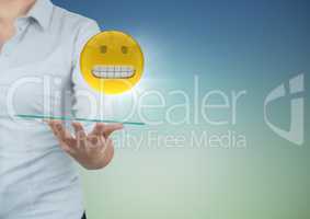 Business woman mid section with tablet and emoji and flare against blue green background