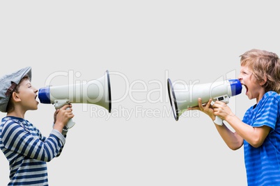 Boys shouting on megaphones while standing against gray background