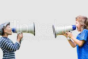 Boys shouting on megaphones while standing against gray background