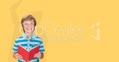 Digitally generated image of smiling boy holding book with shadow of graduate student in yellow back