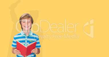 Digitally generated image of smiling boy holding book with shadow of graduate student in yellow back