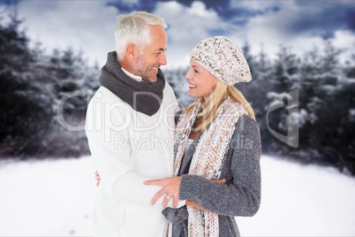 Side view of affectionate senior couple standing at field during winter