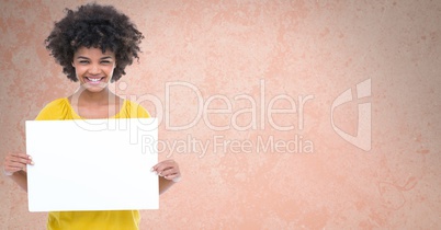 Portrait of smiling woman holding blank billboard while standing against brown background