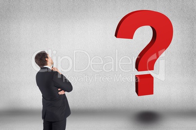 Business man looking question mark against gray background