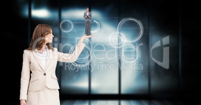 Businesswoman holding employee in palm over abstract background