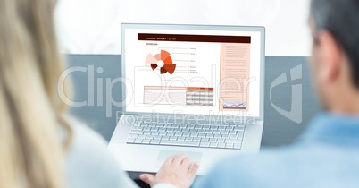 Rear view of business people making graphs on laptop