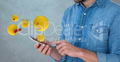 Midsection of man using smart phone while emojis coming out from it