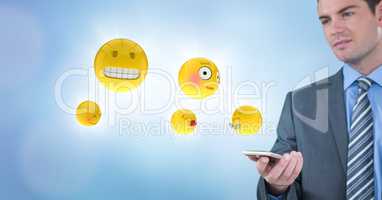 Business man with phone and emojis with flares against blue background