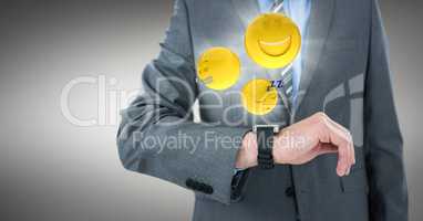 Business man mid section with watch and emojis with flares against grey background