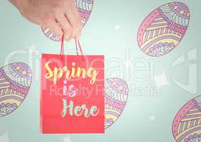 Hand holding red bag with with type against blue easter pattern