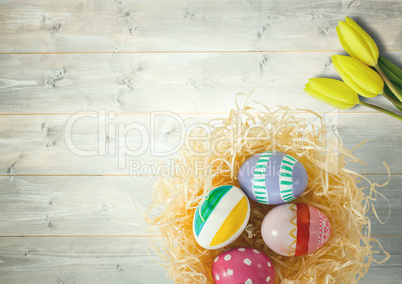 Happy Easter table with flowers and nest with eggs.