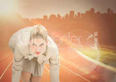 Business woman at start line against orange flare and skyline