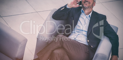 Businessman sitting on a chair and talking on mobile phone