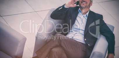 Businessman sitting on a chair and talking on mobile phone