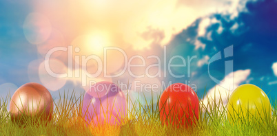 Composite image of mulit colored shiny easter eggs on grass