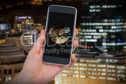 Composite image of hand holding mobile phone against white background