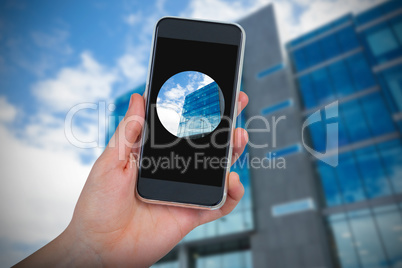 Composite image of hand holding mobile phone against white background