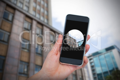 Composite image of hand holding mobile phone against white background