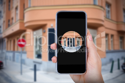 Composite image of hand holding mobile phone against white background