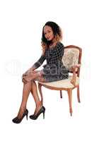 Tall young lady sitting in armchair.