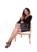 Serious woman sitting in armchair.