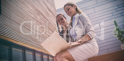 Businesswomen sitting and using laptop